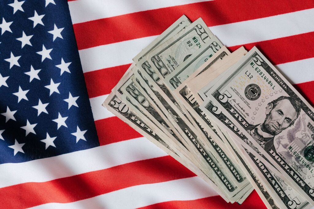 VA loan vs FHA loan: hand holding dollar bills in front of the American flag