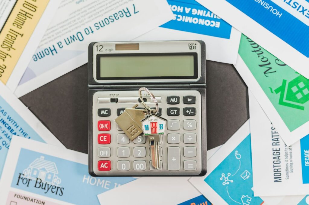 when to refinance: calculator and house keys on top of mortgage rate brochures