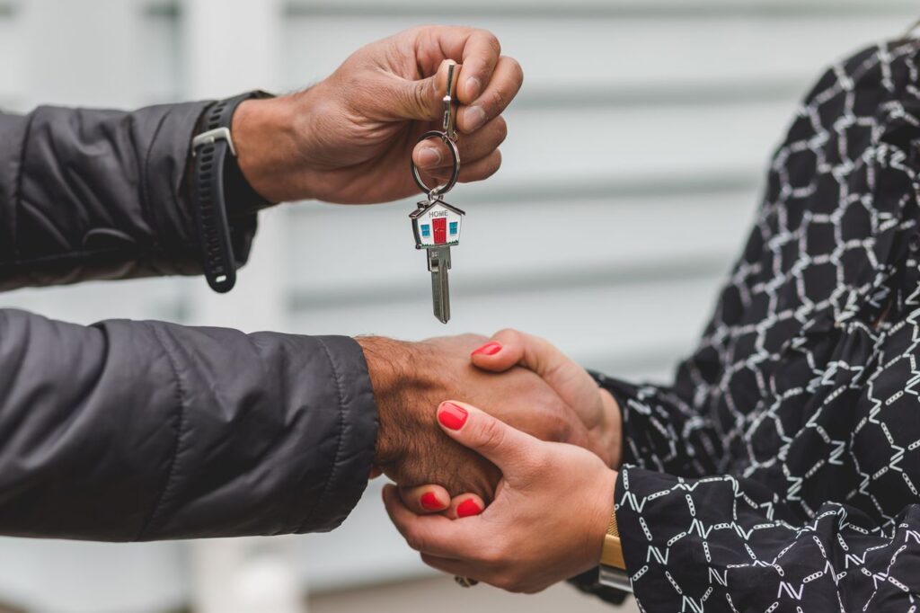 Seller handing house keys to a buyer taking over an assumable mortgage